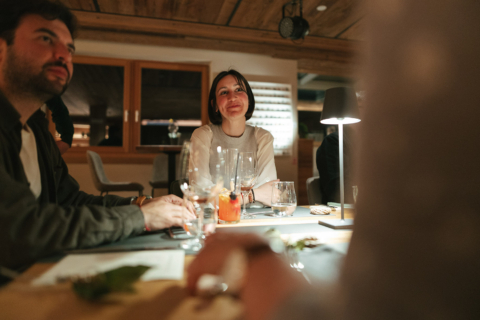 Gäste sitzen entspannt am Community Table und genießen Gespräche in gemütlicher Atmosphäre