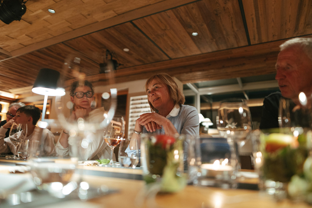 Gäste lachen und genießen den Abend am Community Table im Cyprianerhof