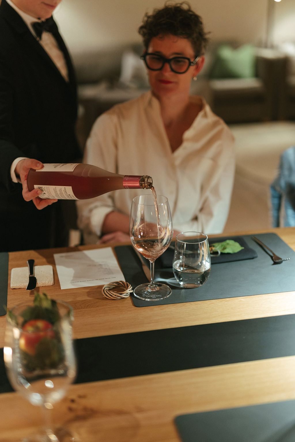 Ein Glas Rosé wird am Community Table im Cyprianerhof eingeschenkt
